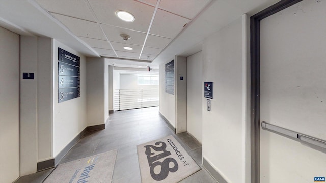 corridor featuring elevator and a drop ceiling