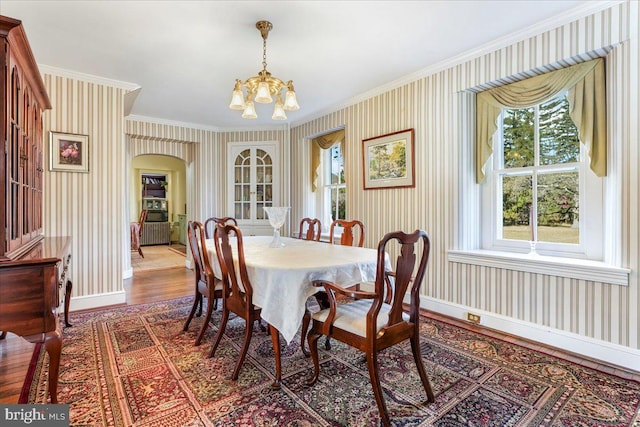 dining area featuring hardwood / wood-style flooring, crown molding, and a notable chandelier