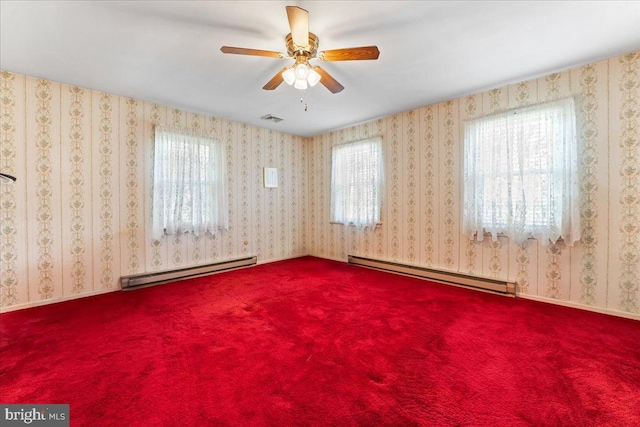 carpeted spare room featuring ceiling fan and a baseboard heating unit