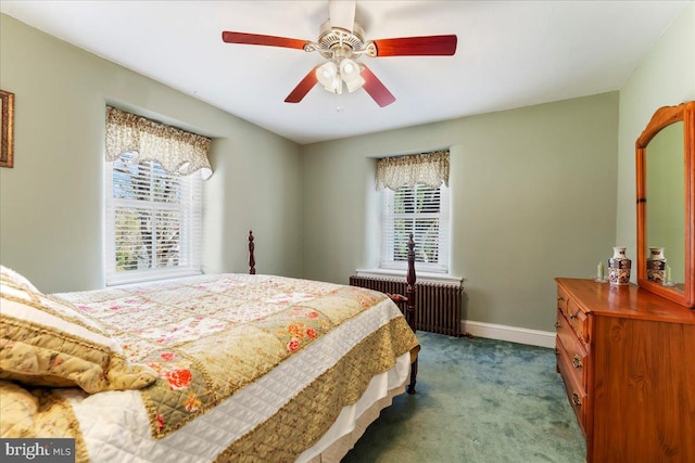 bedroom with ceiling fan, multiple windows, radiator heating unit, and dark carpet