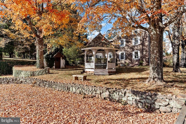 view of front of property featuring a gazebo and a shed