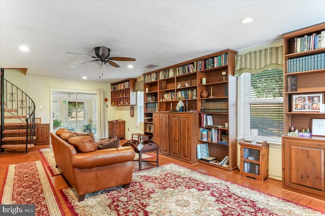 living room featuring light wood-type flooring, plenty of natural light, and ceiling fan