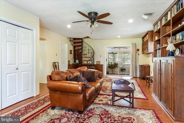 living room featuring a textured ceiling, hardwood / wood-style flooring, and ceiling fan