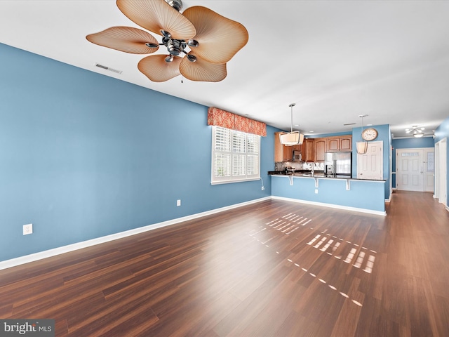 unfurnished living room featuring dark hardwood / wood-style floors and ceiling fan