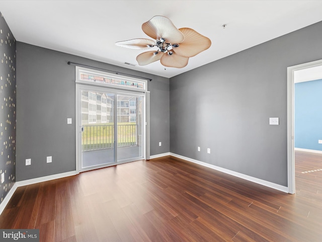 empty room with ceiling fan and dark hardwood / wood-style flooring