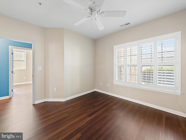 spare room featuring dark hardwood / wood-style flooring and ceiling fan