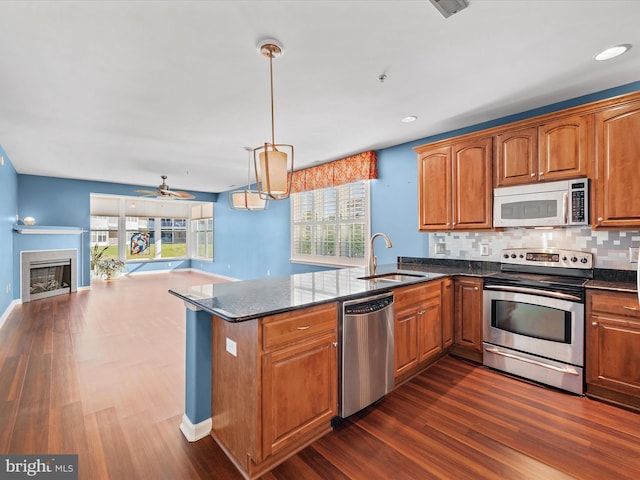 kitchen with sink, ceiling fan, decorative light fixtures, a healthy amount of sunlight, and stainless steel appliances