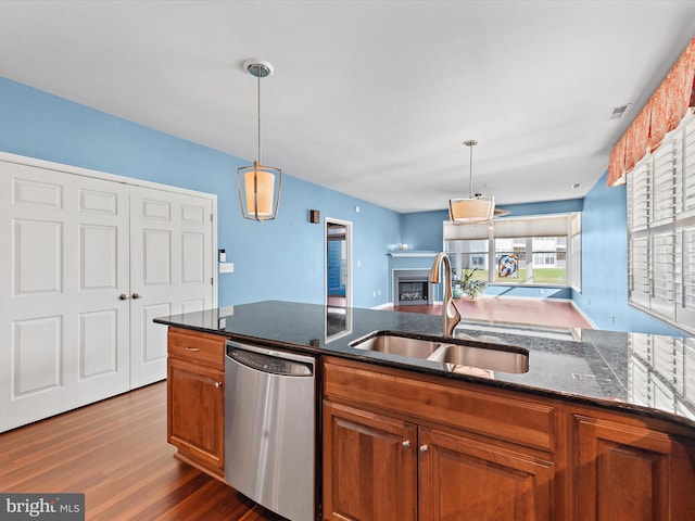 kitchen with dark hardwood / wood-style flooring, sink, stainless steel dishwasher, and decorative light fixtures