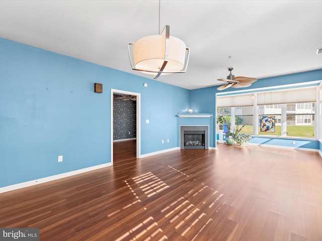 unfurnished living room featuring dark hardwood / wood-style floors and ceiling fan