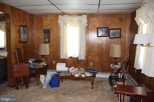 sitting room featuring wooden walls, carpet floors, and a baseboard heating unit