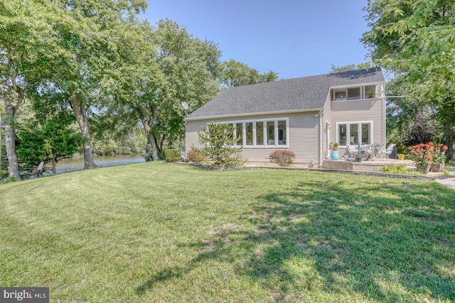 rear view of house with a patio and a lawn