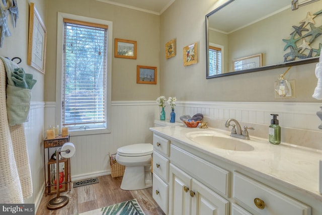 bathroom with hardwood / wood-style flooring, ornamental molding, toilet, and vanity