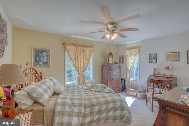 carpeted bedroom featuring multiple windows and ceiling fan