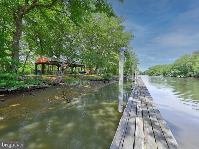 view of dock with a gazebo and a water view