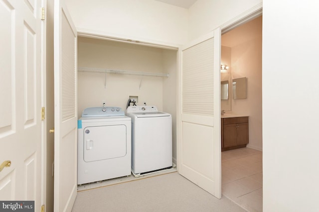 laundry room featuring washer and clothes dryer and light tile patterned floors