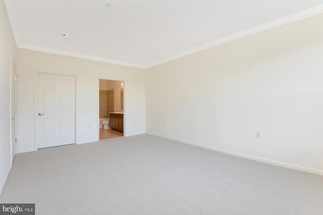 unfurnished bedroom with ensuite bathroom, light colored carpet, and crown molding