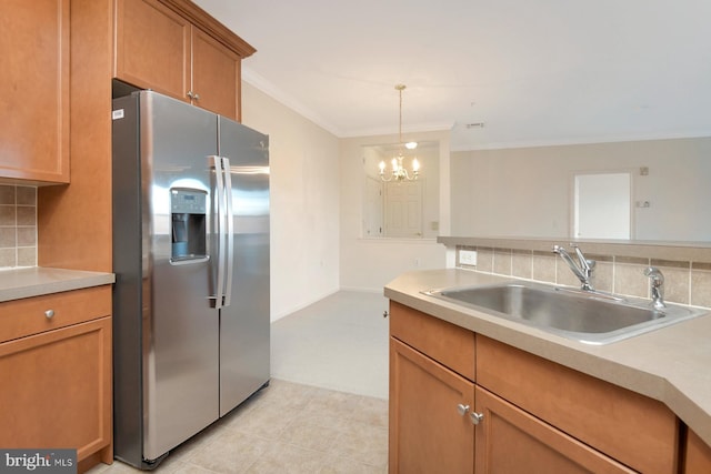 kitchen with an inviting chandelier, crown molding, sink, tasteful backsplash, and stainless steel fridge with ice dispenser