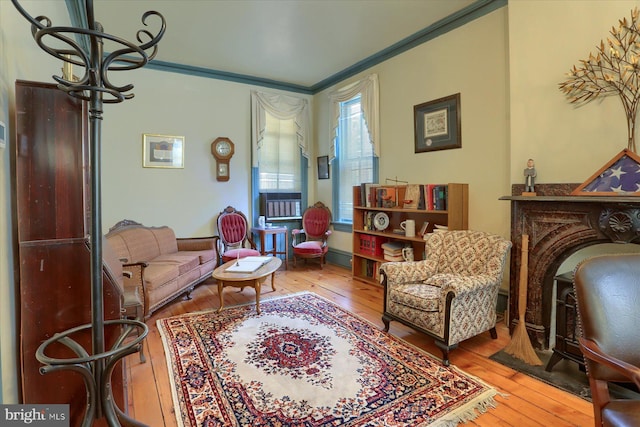 living area featuring hardwood / wood-style flooring, a notable chandelier, and crown molding