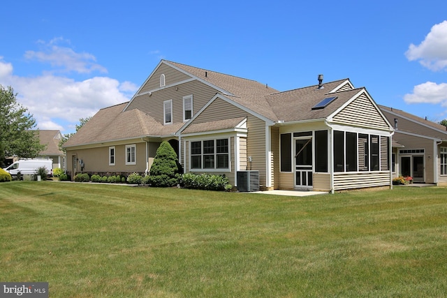 back of property featuring central air condition unit, a lawn, and a sunroom