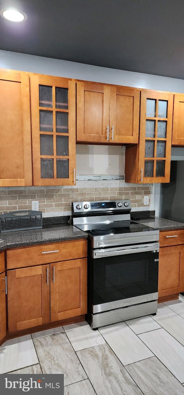 kitchen featuring tasteful backsplash, extractor fan, and stainless steel range with electric stovetop