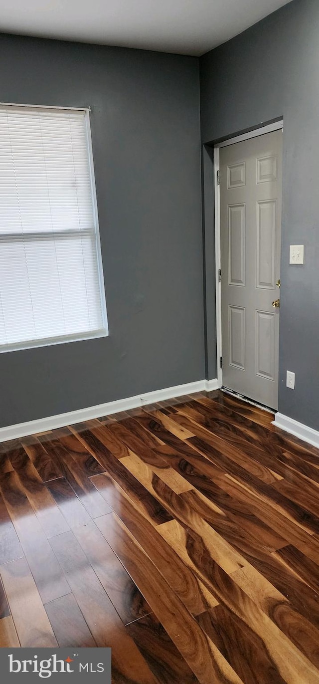 empty room with dark wood-type flooring