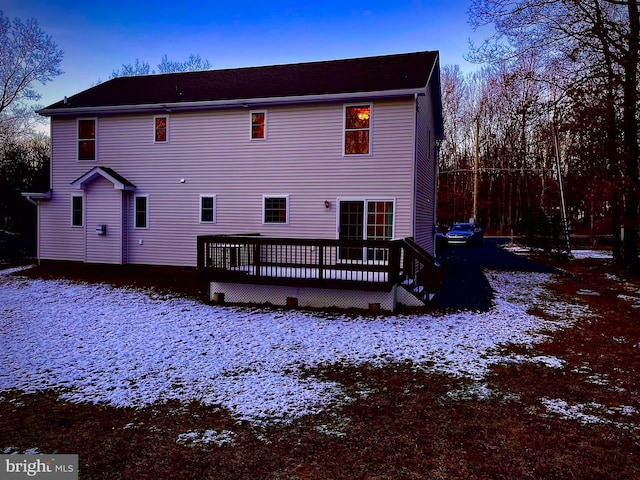 snow covered property with a deck