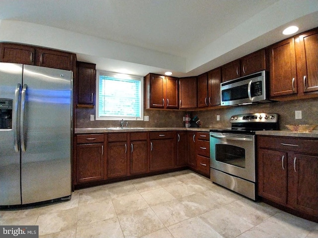 kitchen with decorative backsplash, light tile patterned flooring, sink, and appliances with stainless steel finishes