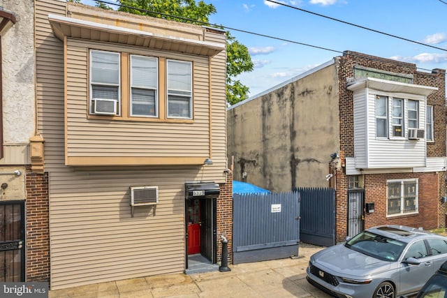 view of side of property with a wall mounted AC and cooling unit