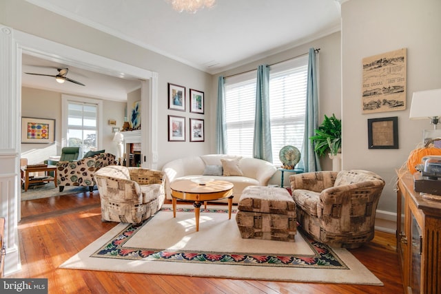 living room with ceiling fan, dark hardwood / wood-style flooring, and ornamental molding