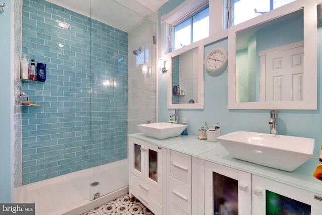 bathroom with tiled shower, vanity, and tile patterned floors