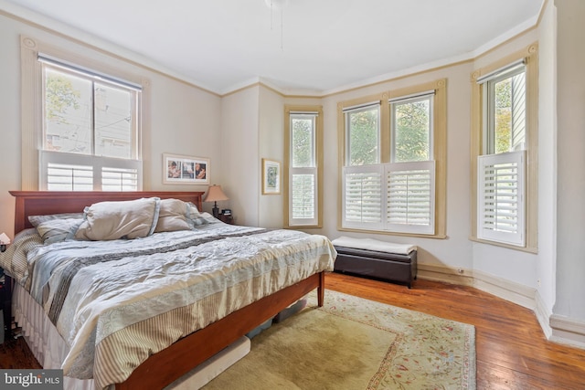 bedroom featuring wood-type flooring and ornamental molding