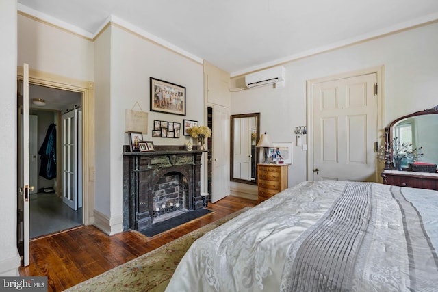 bedroom with crown molding, dark hardwood / wood-style floors, and a wall unit AC