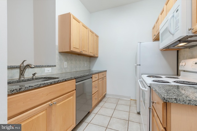 kitchen featuring sink, light brown cabinets, dark stone counters, white appliances, and light tile patterned flooring