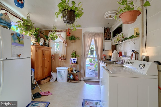 clothes washing area with washer / clothes dryer and sink