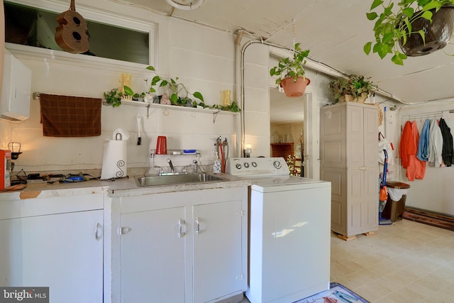 kitchen featuring white cabinets, sink, and washer / clothes dryer