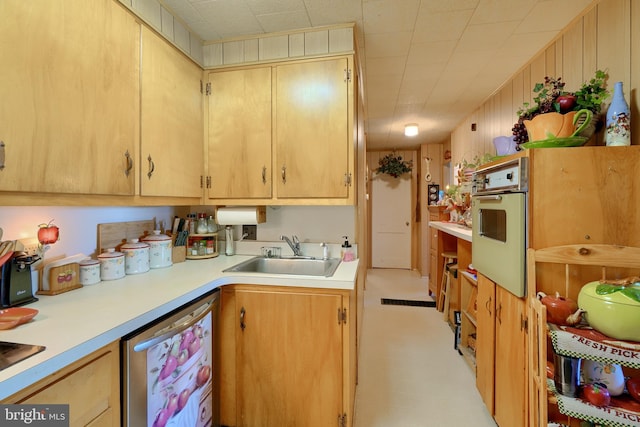 kitchen featuring oven, light brown cabinets, dishwasher, and sink