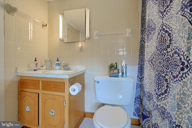 bathroom featuring a shower with curtain, vanity, toilet, and tile walls