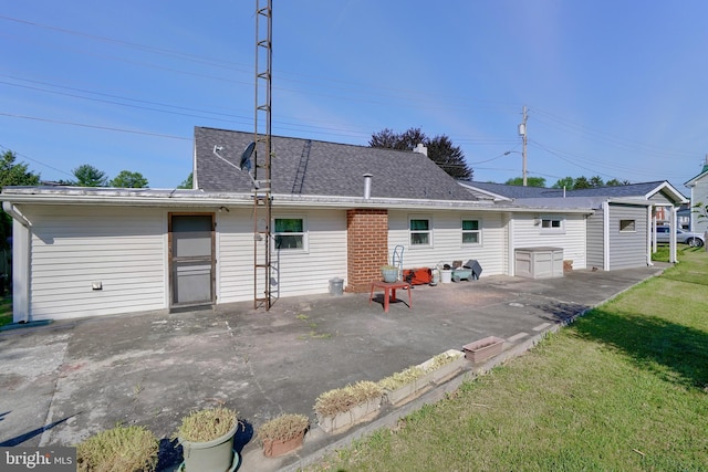 back of property with a lawn and a patio