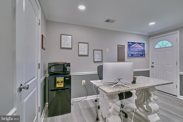 office area with light hardwood / wood-style floors and crown molding