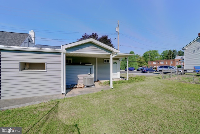 rear view of property featuring a porch, a yard, and central air condition unit