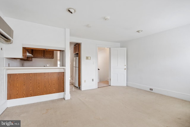 unfurnished living room with a wall mounted AC and light colored carpet