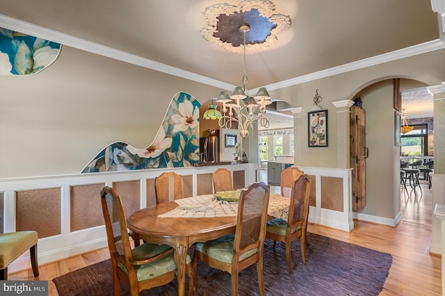 dining area featuring plenty of natural light, a notable chandelier, crown molding, and light hardwood / wood-style flooring