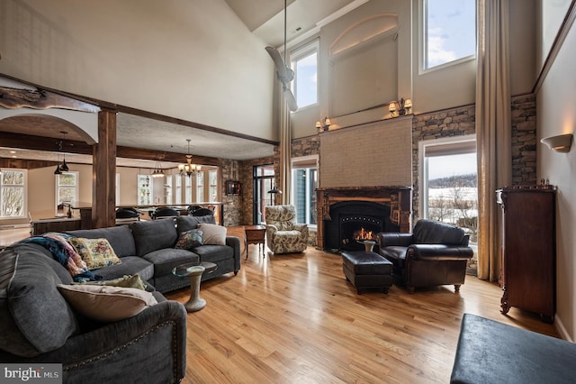 living room featuring a high ceiling, light hardwood / wood-style flooring, and a wealth of natural light