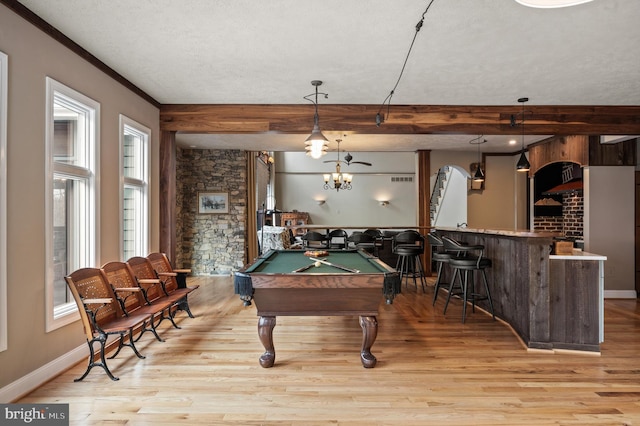 game room featuring pool table, indoor bar, a textured ceiling, light hardwood / wood-style flooring, and ornamental molding