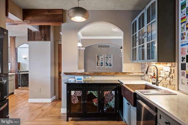 kitchen with dishwasher, a textured ceiling, pendant lighting, beam ceiling, and sink