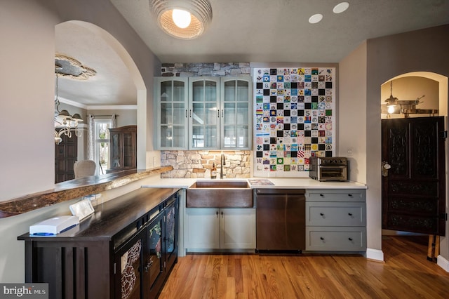 kitchen featuring dishwasher, light hardwood / wood-style flooring, decorative backsplash, gray cabinets, and sink