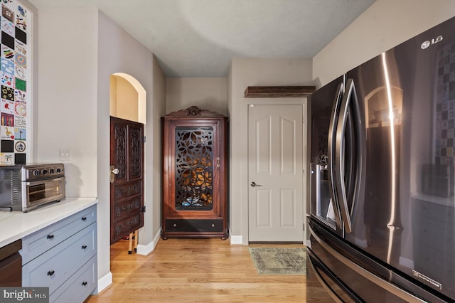 kitchen featuring stainless steel fridge with ice dispenser and light wood-type flooring