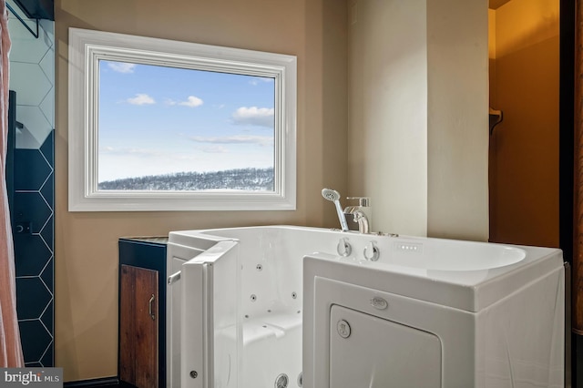 bathroom featuring a tub to relax in and a wealth of natural light