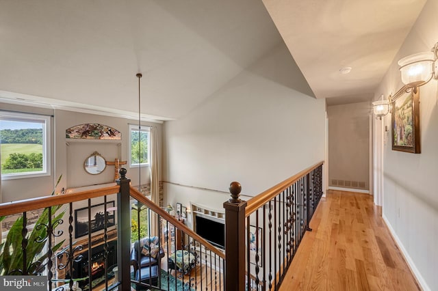 hallway featuring light hardwood / wood-style floors and vaulted ceiling