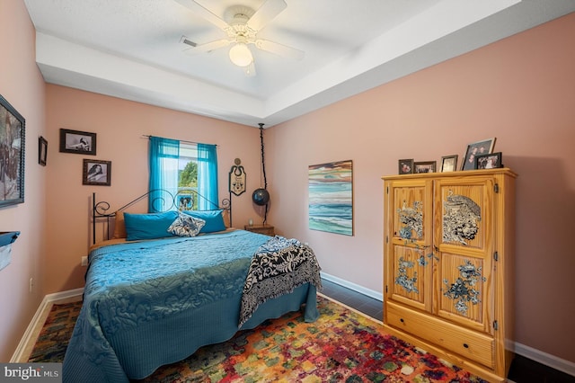 bedroom featuring ceiling fan and a raised ceiling